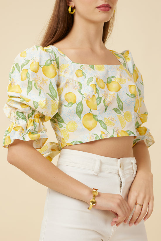 Close-up of the Citrus Dream Crop Top, emphasizing the rectangle neckline, custom lemon print, and the delicate puff sleeves with elastic frill ends, capturing the top’s vibrant essence and light feel.