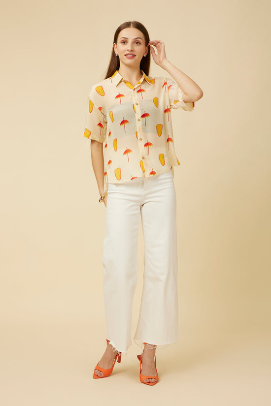 Model dressed in the Ivory Spree Shirt paired with white pants, highlighting the shirt's subtle design and sheer fabric, perfect for sophisticated layering