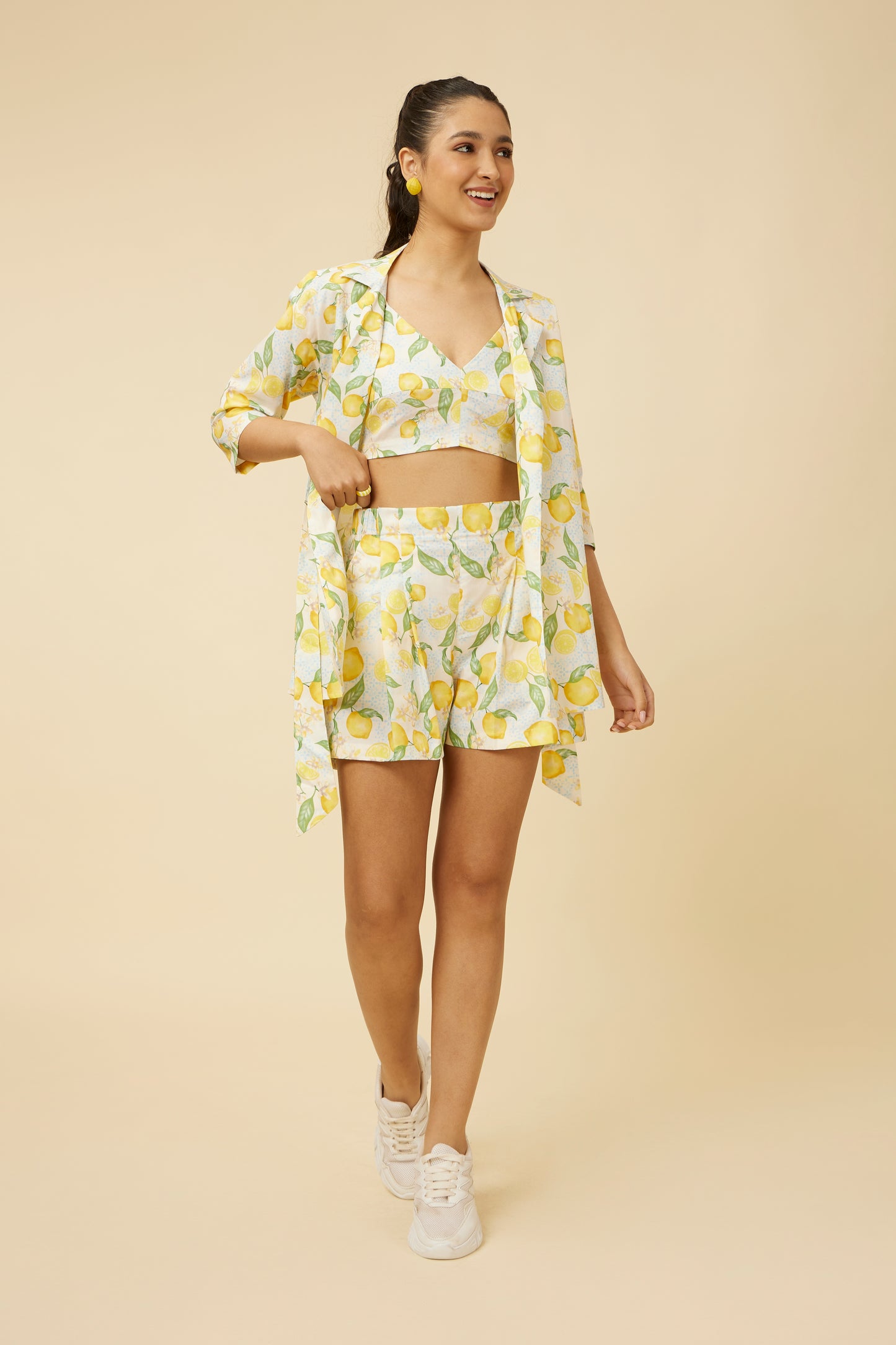 Model wearing the Citrus Dream Shorts with matching shirt, the entire outfit adorned with a zesty lemon print, featuring shorts with a comfort fit and elastic back, providing a breezy and fashionable choice for warm weather.