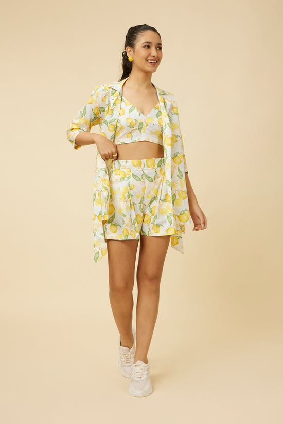 Model wearing the Citrus Dream Shorts with matching shirt, the entire outfit adorned with a zesty lemon print, featuring shorts with a comfort fit and elastic back, providing a breezy and fashionable choice for warm weather.