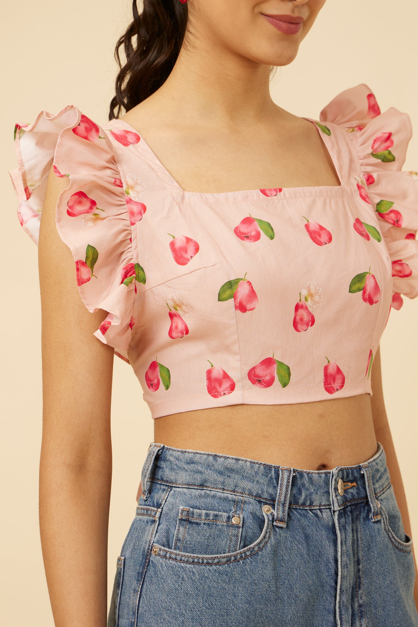 Close-up of the Rose Apple Frill Crop Top detailing the frill accents and the vibrant rose print on a soft pink fabric