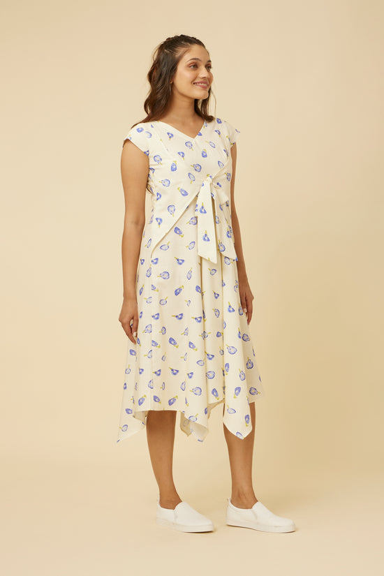Model in Hypsway's Blue Pea Dress showcasing the stylish V-neck and the flattering fit with front ties, combined with the casual elegance of the handkerchief hem, encapsulating a modern twist on summer floral fashion.